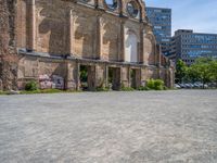 a brick building with some parked cars in front of it and an old style church