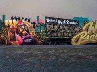 a wall painting on a brick surface with a lot of beer barrels and people near by