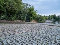 an empty cobble floor with trees and grass around it on the banks of a river