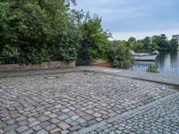 an empty cobble floor with trees and grass around it on the banks of a river