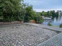 an empty cobble floor with trees and grass around it on the banks of a river