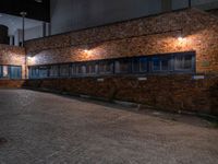 some dark blue windows in an industrial building with no one on the street to the right