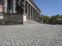 a stone walkway near a statue in a public space, outdoors, during the day