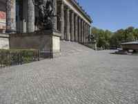 a stone walkway near a statue in a public space, outdoors, during the day