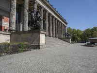 a stone walkway near a statue in a public space, outdoors, during the day