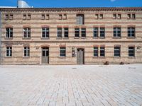 a brick building with multiple windows that are attached to the side of it, in the middle of the courtyard