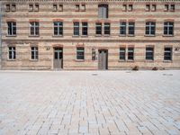 a brick building with multiple windows that are attached to the side of it, in the middle of the courtyard