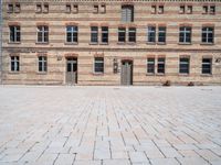 a brick building with multiple windows that are attached to the side of it, in the middle of the courtyard