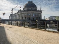 a street with a walkway over the water and the building on top is in the background