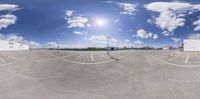 an 360 - mirror photograph shows a parking lot with a building in the background and cars parked nearby