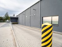 an image of a yellow and black stripe posts next to a building entrance entrance is visible