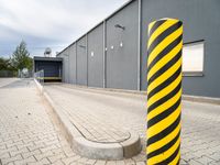 an image of a yellow and black stripe posts next to a building entrance entrance is visible