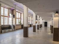 a room filled with lots of windows and white pillars with purple lights on top of them