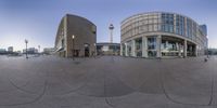 an image of a fish eye lens shot of the architecture in dublin, ireland, with the television tower in the background