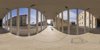 a photo of different images of buildings through a circular mirror of a person walking in a parking lot