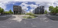 the street looks like a spherical panorama of a campus courtyard, and is in front of large modern apartment buildings