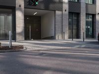 a traffic light sits in front of an office building on a street corner, with two streets
