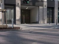a traffic light sits in front of an office building on a street corner, with two streets