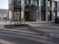 a traffic light sits in front of an office building on a street corner, with two streets