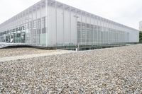 a large building is on a gravel roof with a man walking across it looking at the sidewalk