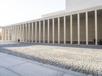 a building with columns that have been built over the floor to make a walkway across it