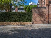 a long empty brick street with tall buildings in the background on a sunny day with some people walking around