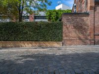 a long empty brick street with tall buildings in the background on a sunny day with some people walking around