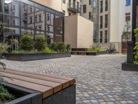 an empty parking lot with plants in the ground and on the side of the building, there is an enclosed area and windows