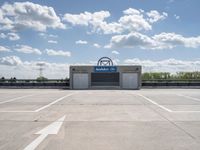 a parking lot at a business with a cloudy background, including white puffy clouds