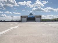 a parking lot at a business with a cloudy background, including white puffy clouds