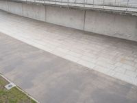 a person doing a skateboard trick on a ramp under a concrete wall outside the building