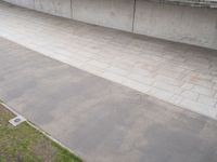 a person doing a skateboard trick on a ramp under a concrete wall outside the building