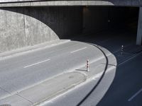 a city street with a road over the street that goes under an overpass with no cars