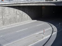 a city street with a road over the street that goes under an overpass with no cars