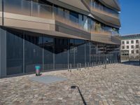 the large office building is located in the center of a cobblestone plaza of the city