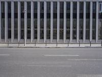 an empty street is lined with long vertical poles that have been placed on the wall