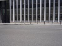 an empty street is lined with long vertical poles that have been placed on the wall