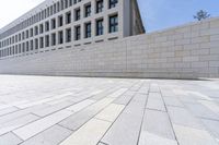 a brick path that is in front of an office building and a wall on the side of it