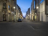 a car drives down an empty city street at night in the middle of the day