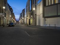 a car drives down an empty city street at night in the middle of the day