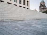 this image has an empty wall and buildings in the background and a man skateboarding