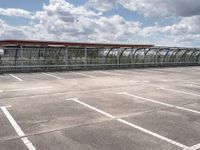 train in the middle of a parking lot with no people on it and cloudy skies above