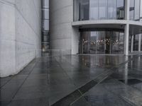a black umbrella sitting outside the entrance to a building with many doors opened on the side