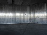 an industrial building features high ceiling and concrete flooring with a thin corrugated metal wall