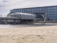 there is a train that is on the tracks going over the water by some sand