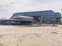 there is a train that is on the tracks going over the water by some sand