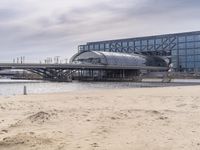 there is a train that is on the tracks going over the water by some sand