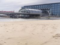 there is a train that is on the tracks going over the water by some sand