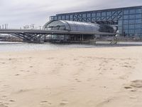 there is a train that is on the tracks going over the water by some sand