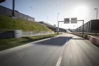 a long road next to an industrial area and parking lot with street lights on the side